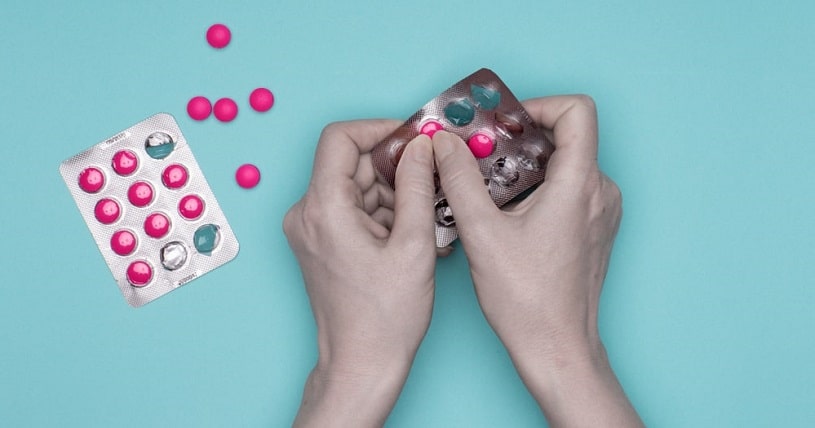 Female hands holding blister pack with pills.