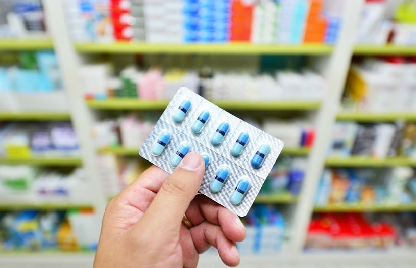 Pharmacist holding Meloxicam capsule pack at the drugstore.
