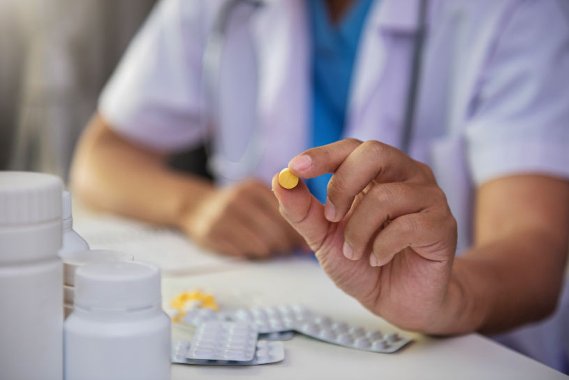 A medical worker holds Phenobarbital pill in her hand.