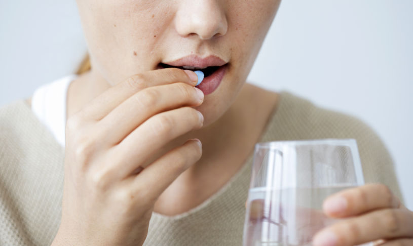 A woman drinks Phenobarbital pill.