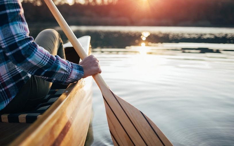 Close up of a girl paddling a canoe.