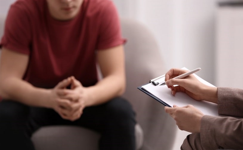 Male patient listening to an addiction counselor.