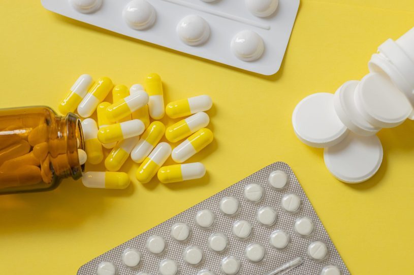 Different tablets and capsules on the yellow table