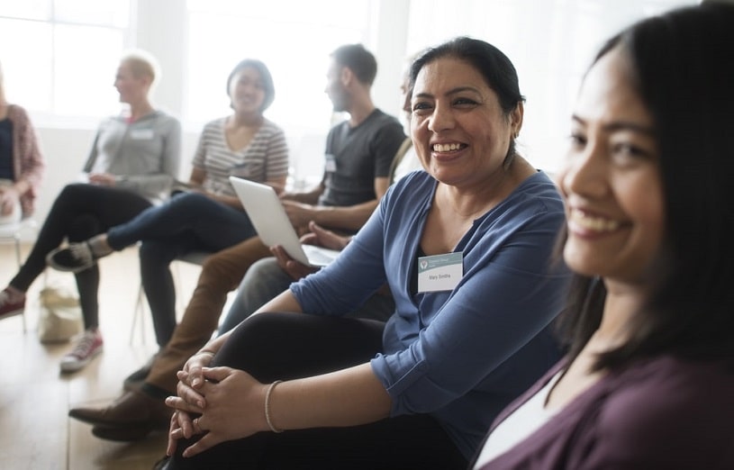 Group of people sitting indoors smiling and communicating.