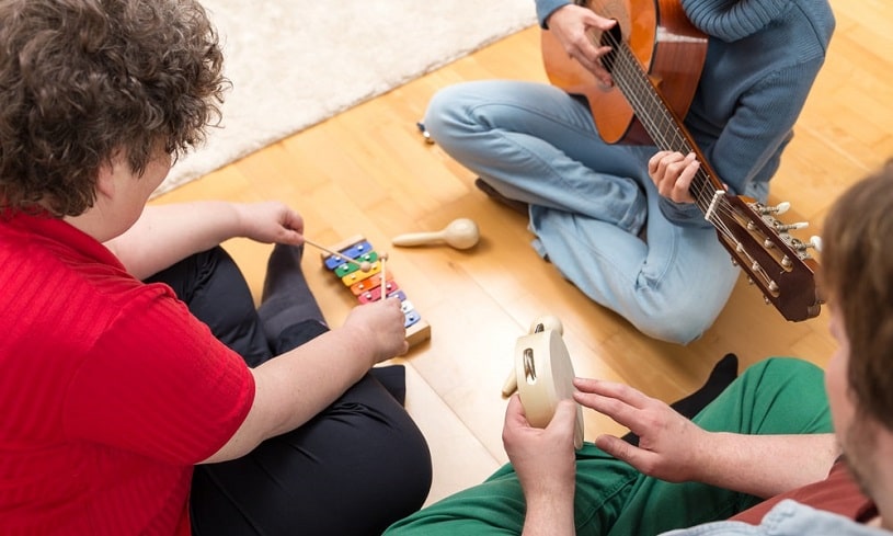 Three people playing musical instruments together.