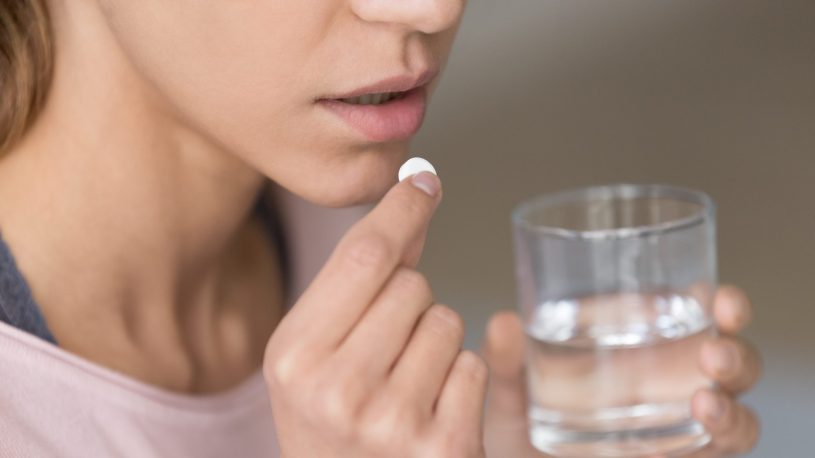 Woman is holding white round pill