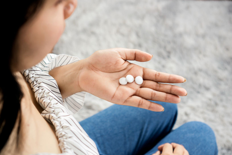 A girl holds Trazodone pills in her hand.