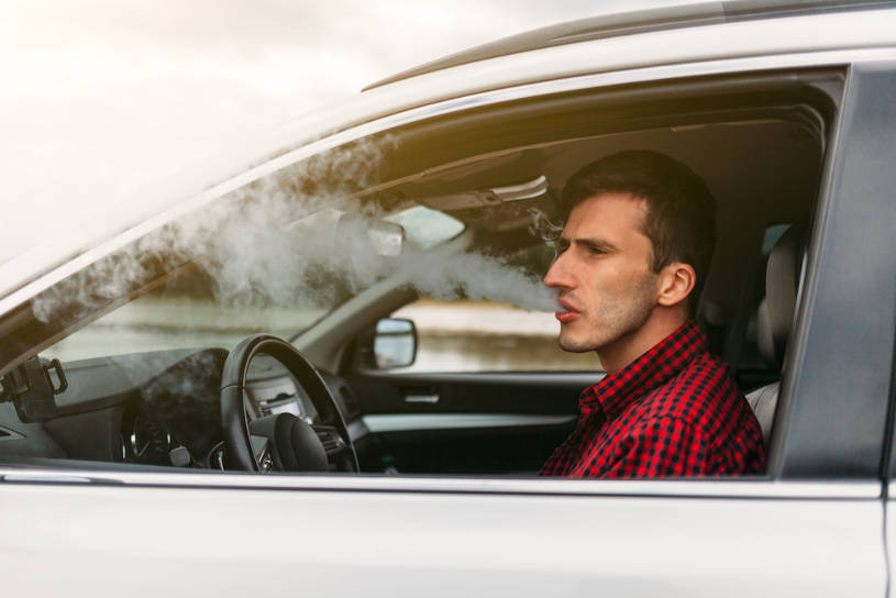 Man smoking weed while driving a car.