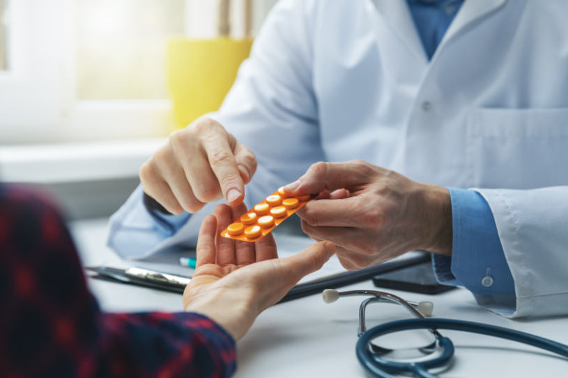 A doctor gives some pills to a patient and explains how to take them.