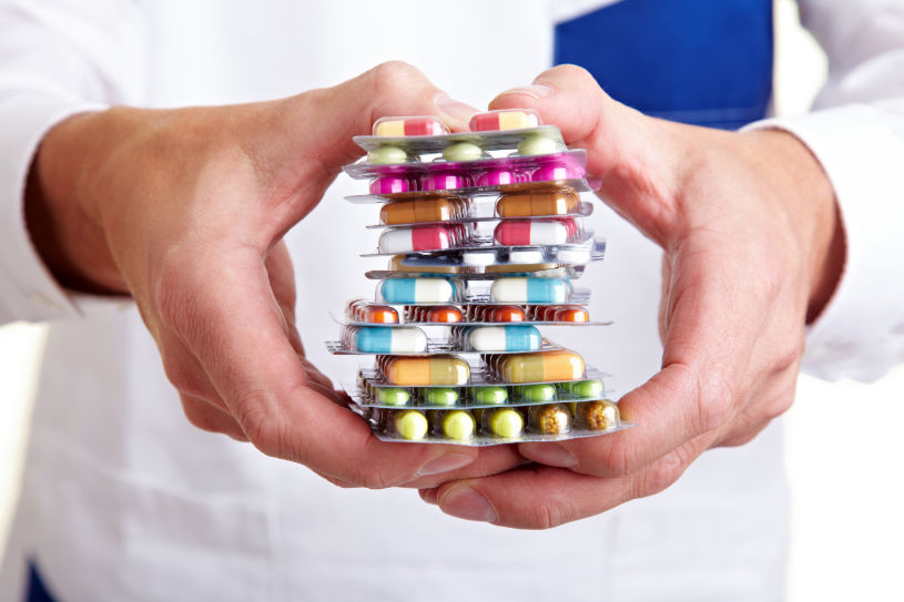 A doctor holds different pills in his hand.
