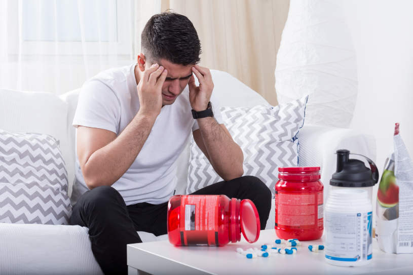 A man experiencing a headache suffers from anabolic-steroids addiction.