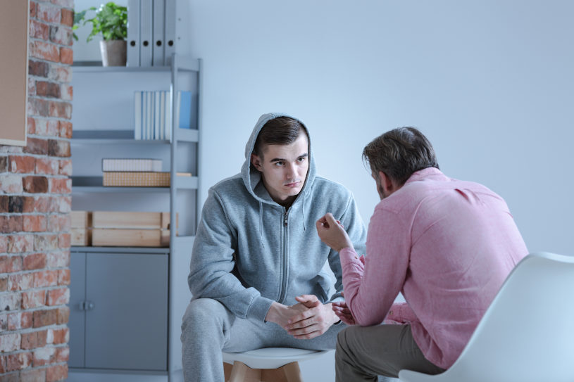 A man speaks with a medical worker in a hospital.