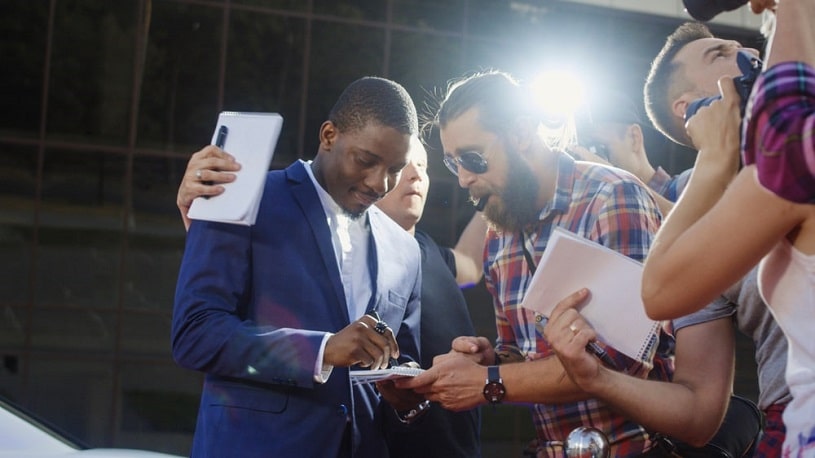 A famous actor giving autographs to fans.