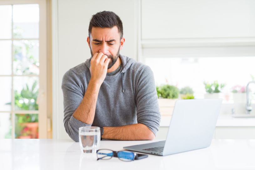 A depressed man looks desperately at the glass of water.