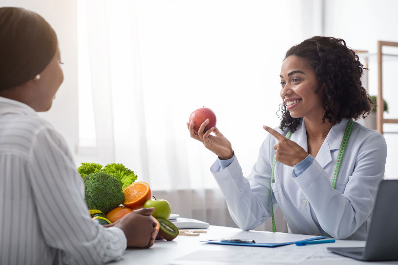 A doctor holds an apple in her hand.