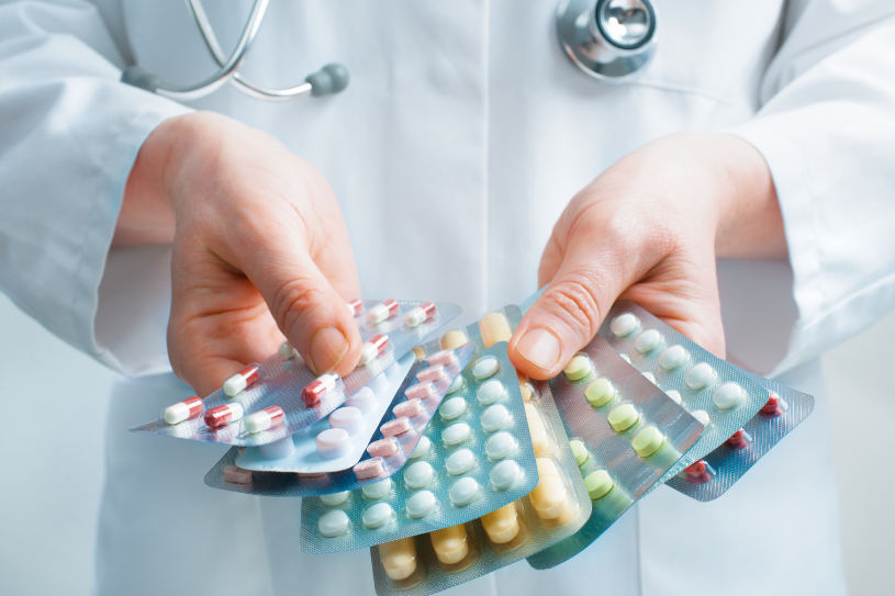 A doctor holds different pills in her hands.