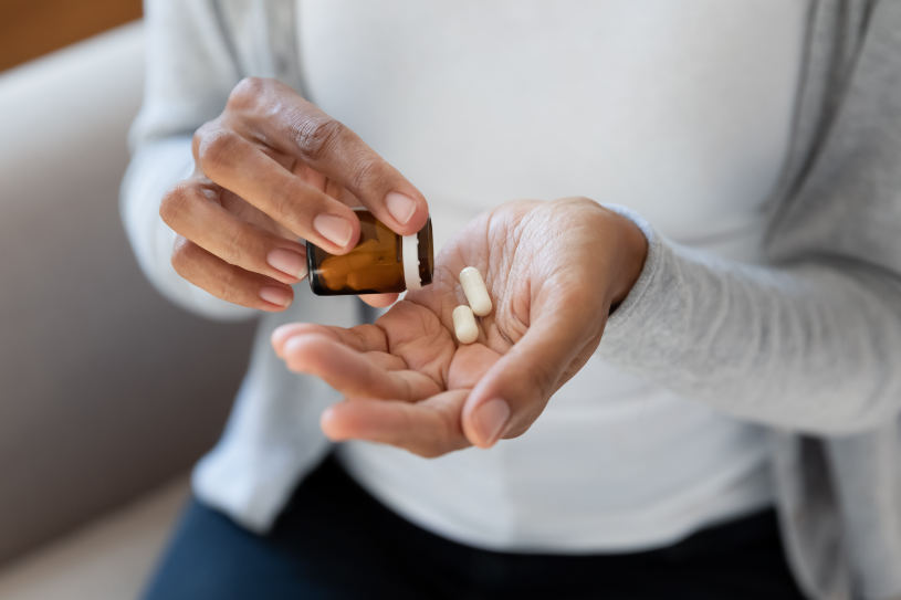 A woman pours Paxil pills in her hand.