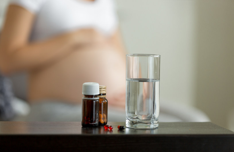 Buspar pills on the table and a pregnant woman over the background.