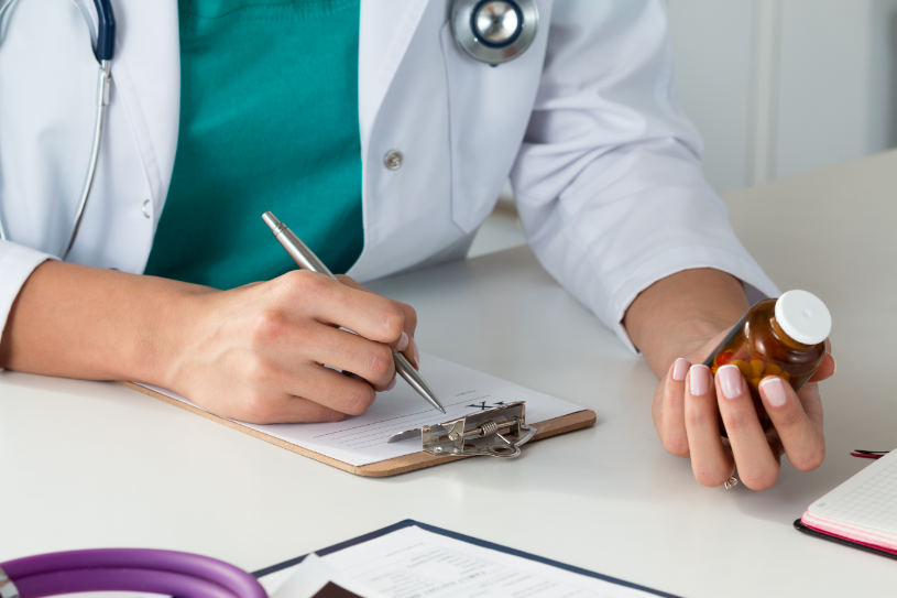 A doctor writes a prescription to a patient.