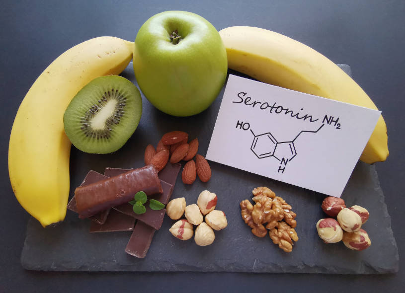 Different fruits and nuts with the inscription serotonin in the paper.