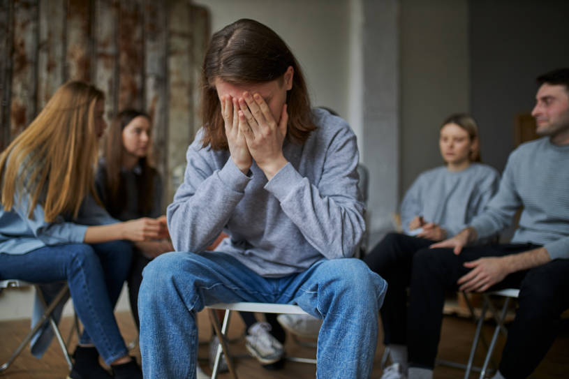 A young man with club drugs addiction sitting in the therapy group meeting.