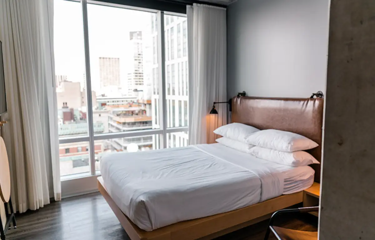 A bed that is beside the room's window