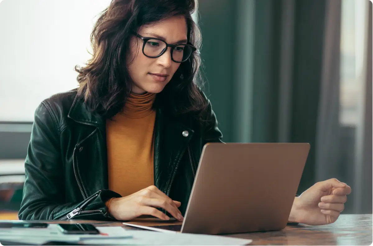 A girl holding working on a laptop.
